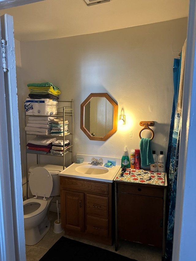 bathroom featuring tile patterned floors, vanity, and toilet