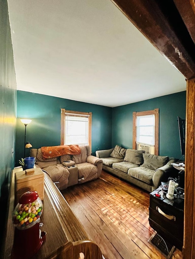 living room featuring beam ceiling and hardwood / wood-style flooring