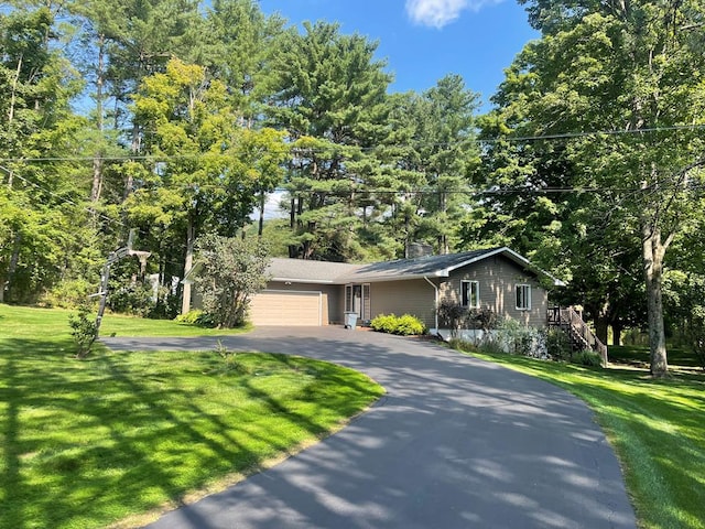 view of front of house with a garage and a front lawn