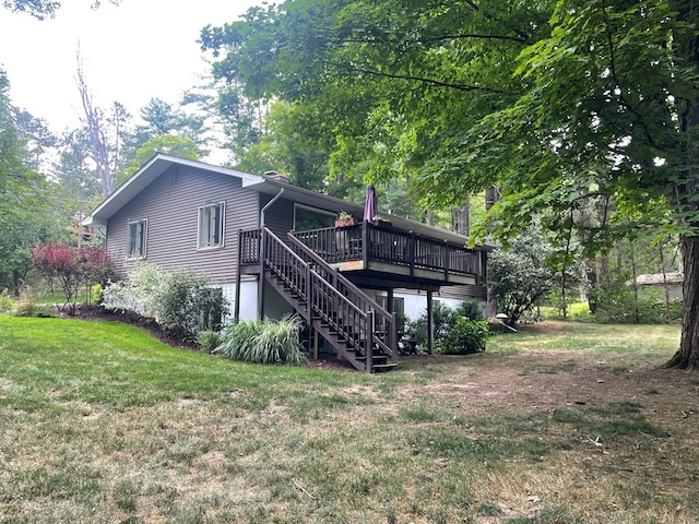 rear view of property featuring a yard and a wooden deck