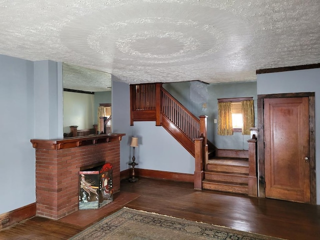 stairway featuring wood-type flooring, a fireplace, and a textured ceiling