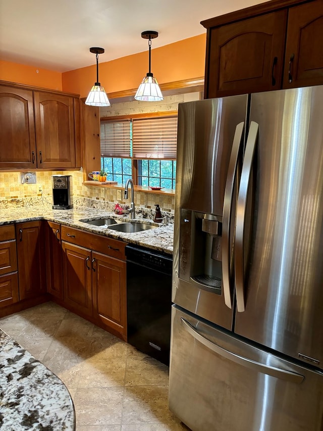 kitchen with sink, dishwasher, light stone counters, stainless steel refrigerator with ice dispenser, and pendant lighting