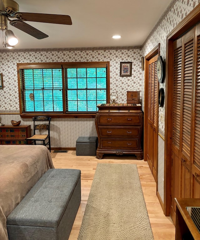 bedroom with ceiling fan, light hardwood / wood-style floors, and crown molding