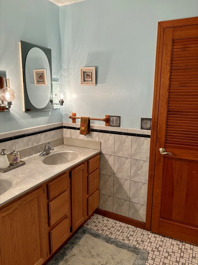 bathroom featuring vanity and tile walls