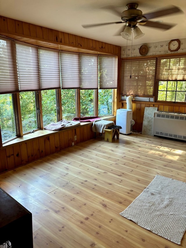 unfurnished sunroom featuring ceiling fan and radiator