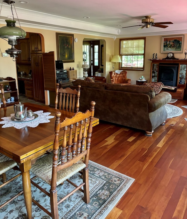 dining area with ceiling fan, crown molding, and wood-type flooring