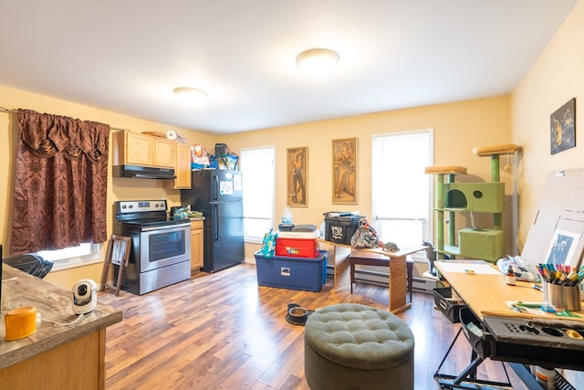 kitchen featuring stainless steel electric range, dark wood-type flooring, light brown cabinetry, and black refrigerator