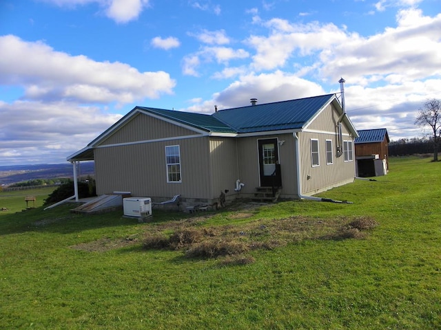 rear view of house featuring a yard