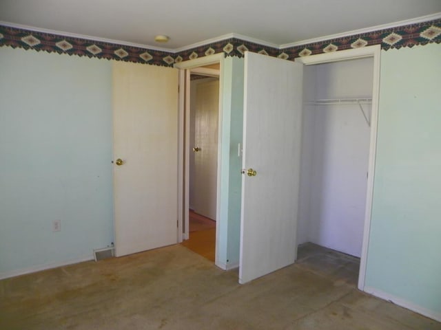 unfurnished bedroom with carpet flooring and a closet