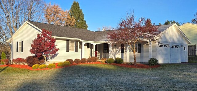 single story home featuring a porch, a front yard, and a garage