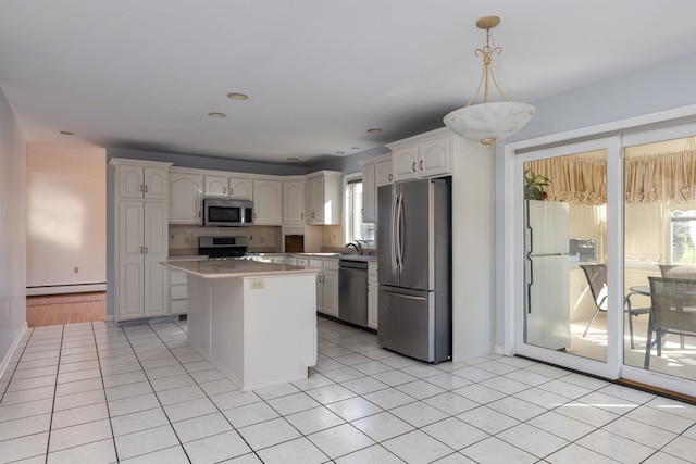 kitchen featuring appliances with stainless steel finishes, white cabinetry, hanging light fixtures, a center island, and baseboard heating