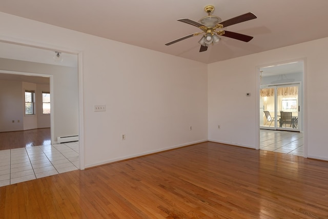 spare room featuring light hardwood / wood-style floors, ceiling fan, and baseboard heating