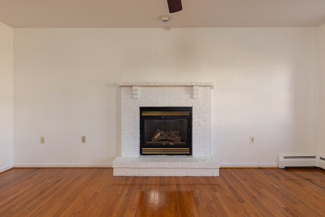 interior details with a brick fireplace, wood-type flooring, and baseboard heating