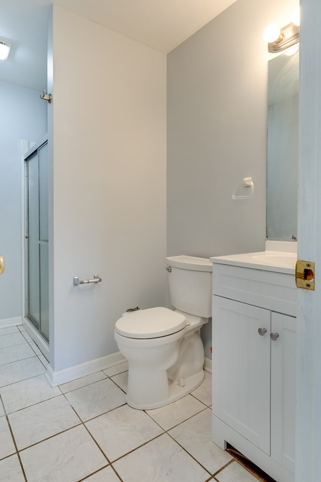 bathroom with vanity, a shower with shower door, tile patterned floors, and toilet