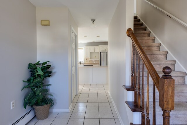 hallway with light tile patterned floors and a baseboard heating unit