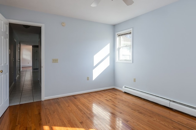 unfurnished room with a baseboard heating unit, wood-type flooring, and ceiling fan