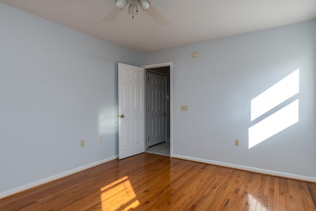 empty room with a skylight, light hardwood / wood-style flooring, and ceiling fan