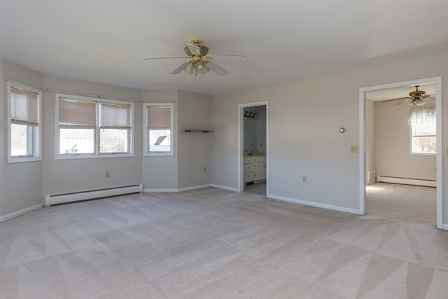 carpeted spare room with a baseboard heating unit, a healthy amount of sunlight, and ceiling fan