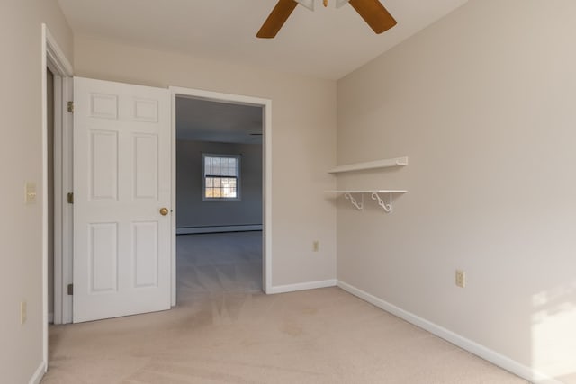 spare room with a baseboard radiator, light colored carpet, and ceiling fan