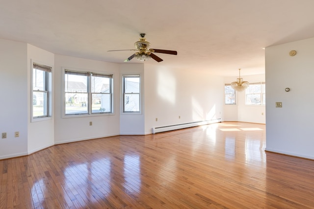 unfurnished room with a baseboard radiator, ceiling fan with notable chandelier, and light wood-type flooring