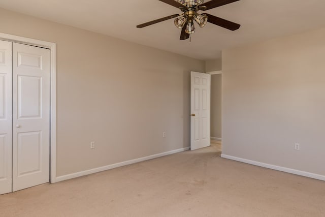 unfurnished bedroom with light carpet, ceiling fan, and a closet