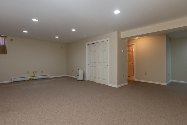 carpeted spare room featuring a baseboard heating unit