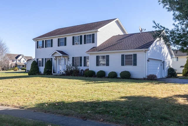 colonial home featuring a garage and a front lawn