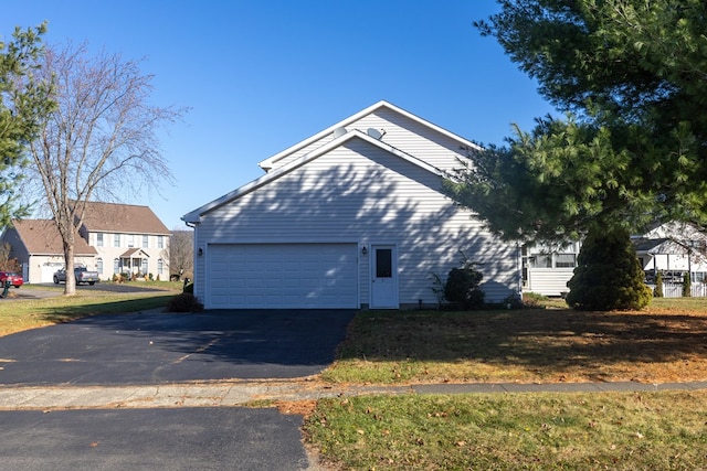 view of side of property with a garage and a lawn