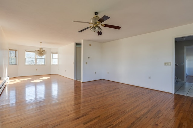 unfurnished room with ceiling fan with notable chandelier and light hardwood / wood-style flooring