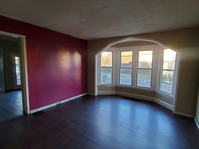 unfurnished room with dark hardwood / wood-style flooring