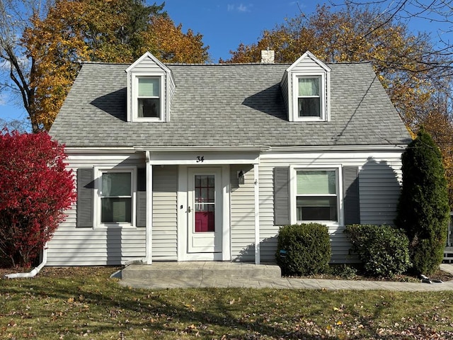 cape cod home featuring a front yard