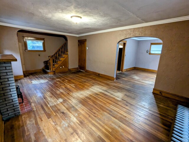 unfurnished living room featuring a textured ceiling, hardwood / wood-style flooring, and crown molding