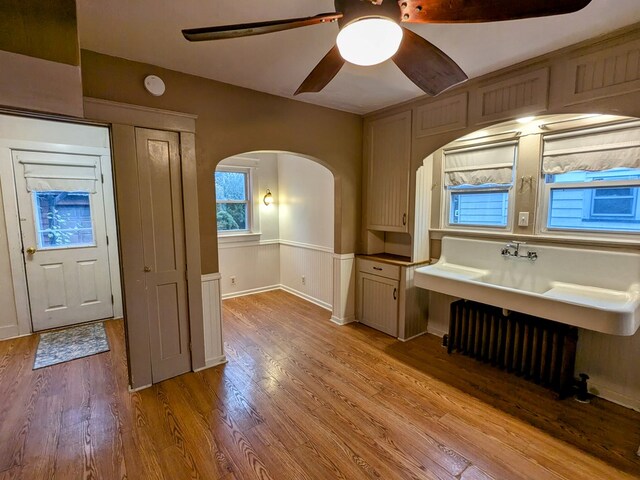 bathroom featuring hardwood / wood-style flooring, ceiling fan, and radiator heating unit