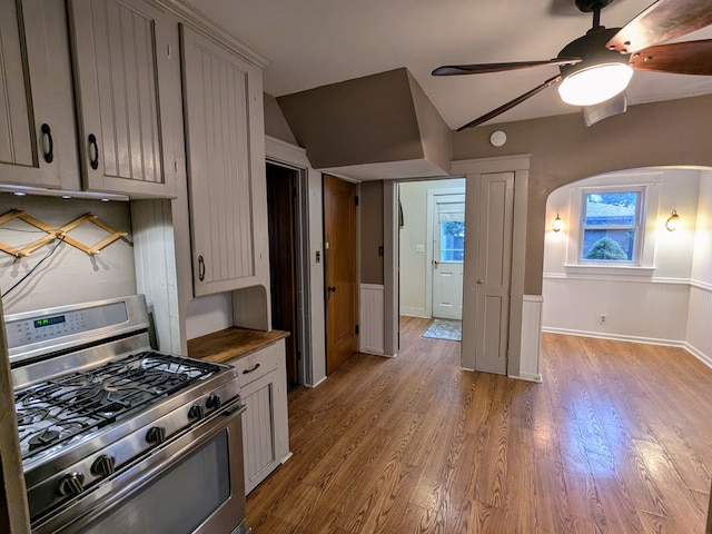 kitchen featuring gas range, ceiling fan, light hardwood / wood-style flooring, and lofted ceiling