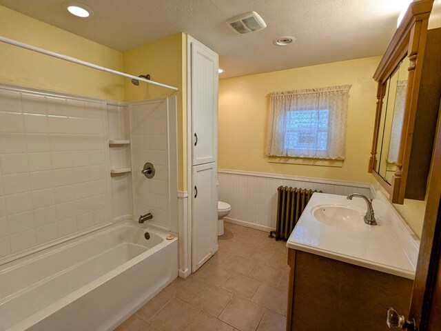 full bathroom featuring radiator, bathing tub / shower combination, a textured ceiling, toilet, and vanity