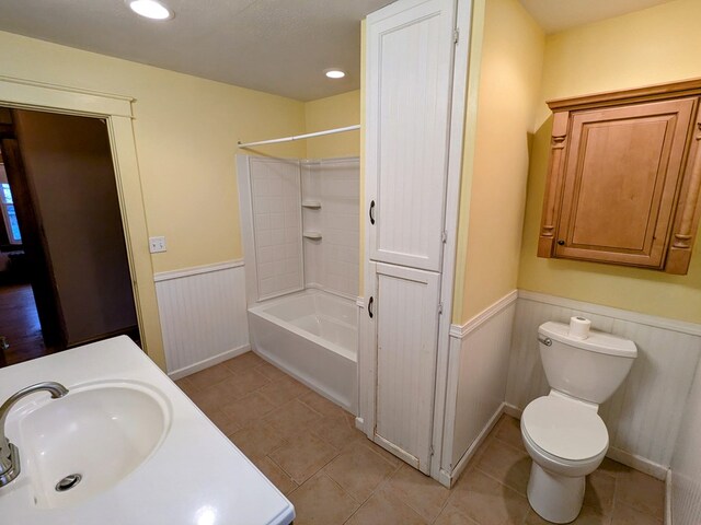 full bathroom featuring toilet, sink, tile patterned flooring, and tub / shower combination