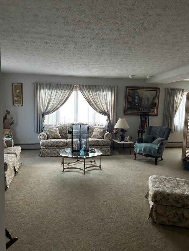 carpeted living room featuring a textured ceiling and a baseboard heating unit