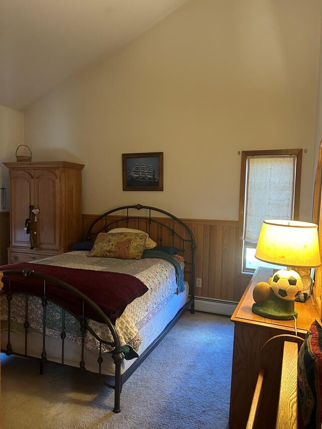 bedroom with carpet flooring, baseboard heating, and vaulted ceiling