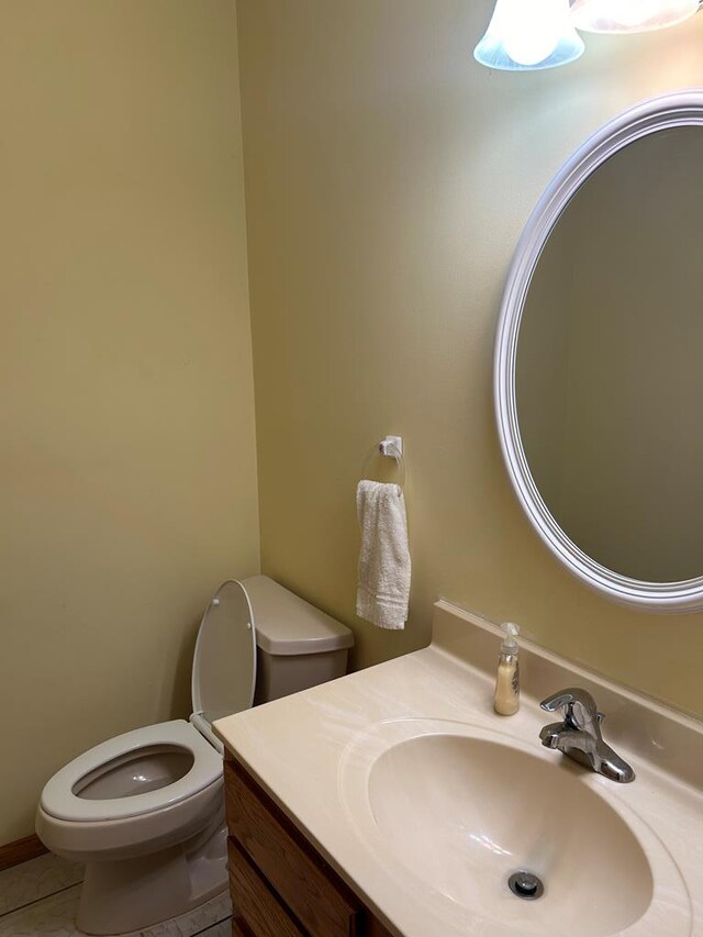 bathroom with toilet, vanity, and tile patterned floors