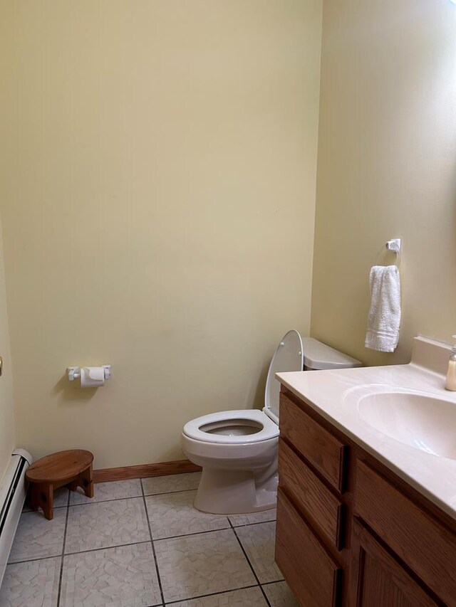 bathroom featuring tile patterned flooring, vanity, toilet, and a baseboard radiator