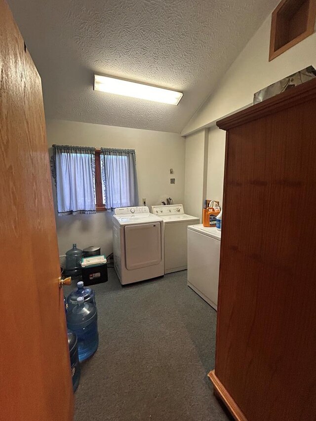 washroom with dark carpet, a textured ceiling, and washing machine and clothes dryer