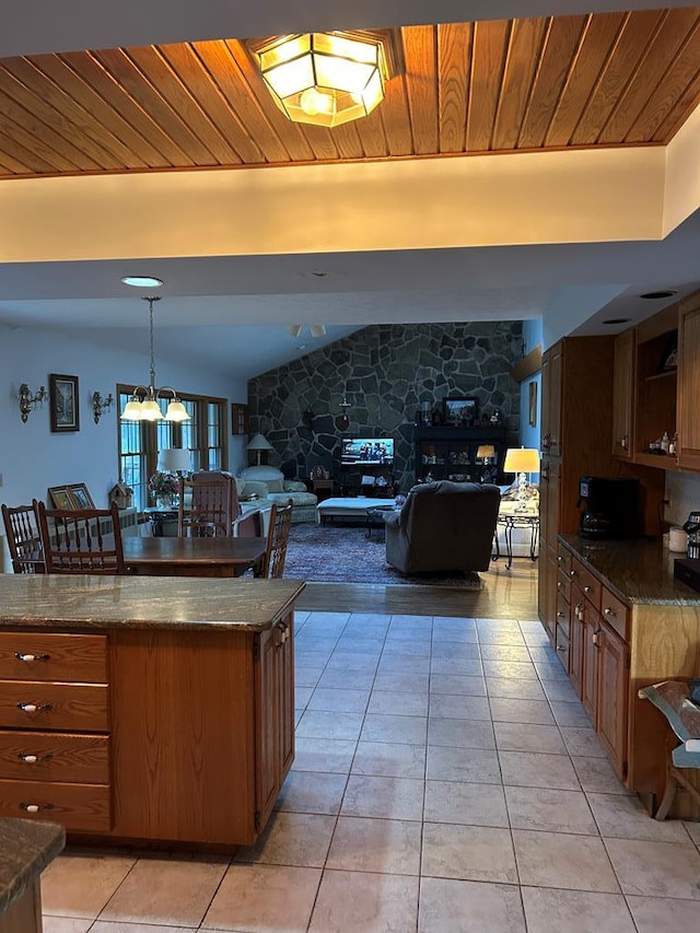 kitchen with decorative light fixtures, dark stone countertops, wood ceiling, and light tile patterned floors