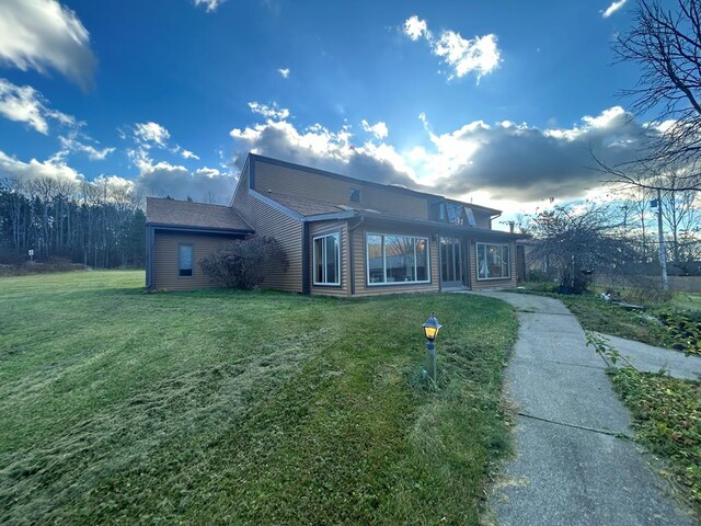 rear view of property featuring a lawn