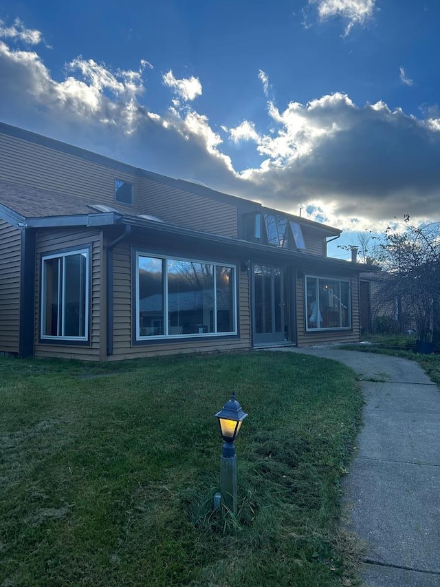 rear view of property featuring a yard