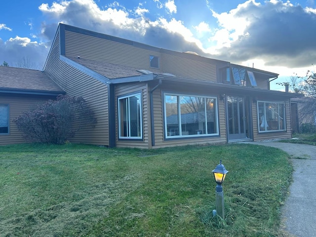 back of house featuring a lawn