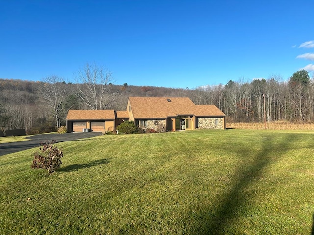 ranch-style house featuring a garage and a front lawn