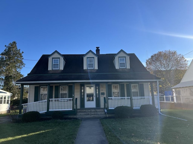 cape cod home featuring a front lawn and covered porch