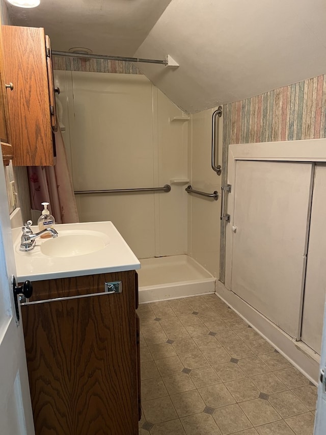 bathroom with vanity, lofted ceiling, and walk in shower