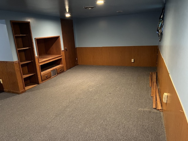 unfurnished living room with wood walls and carpet floors