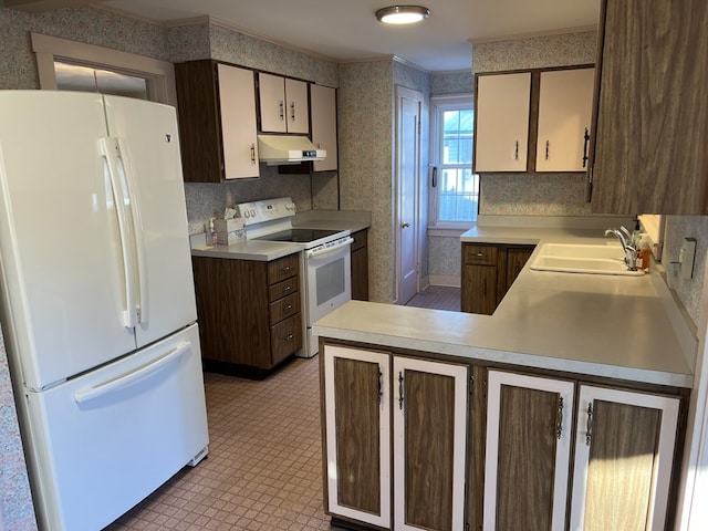 kitchen with kitchen peninsula, dark brown cabinetry, white appliances, and sink